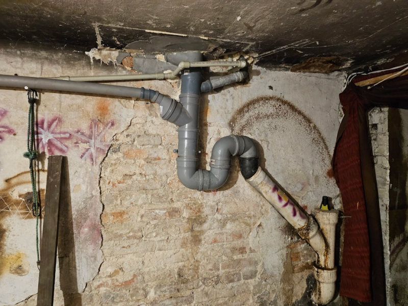 Zasyfonowany pion kanalizacyjny w piwnicy — błąd montażowy niezgodny z PN-EN 12056-2