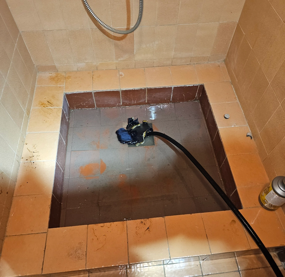 Udrażnianie rur przez brodzik metodą WUKO – wąż wysokociśnieniowy w odpływie brodzika piwnicznego