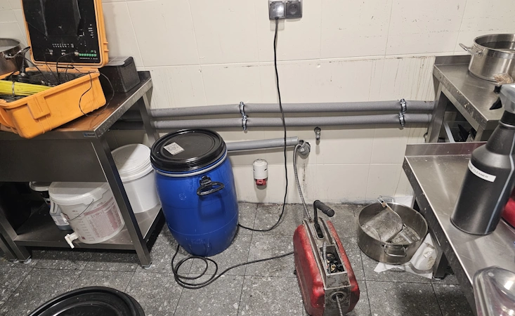 Zatkana kanalizacja – woda stoi w zlewie, hydraulik udrażnia rury